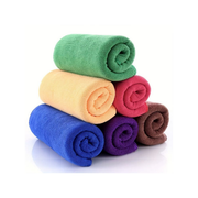 Stack of rolled-up colourful cleaning cloths on a white background
